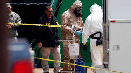 Federal authorities, some in hazmat suits, walk outside the staging area as they search at a small retail space where neighboring business owners said Everett Dutschke used to operate a martial arts studio, in connection with the recent ricin attacks, Wednesday, April 24, 2013 in Tupelo, Miss. No charges have been filed against Dutschke and he hasnt been arrested. (AP Photo/Rogelio V. Solis)
