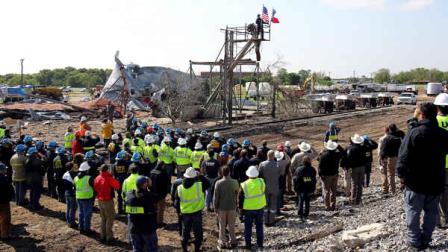 Workers pause for a memorial service at the site of the fire and explosion in West, Texas on Wednesday, April 24, 2013. The explosion at West Fertilizer which killed 14 people left a crater more than 90 feet (27 meters) wide and blasted the walls and windows off dozens of buildings in the town of 2,700. (AP Photo/The San Antonio Express-News, Tom Reel, Pool)