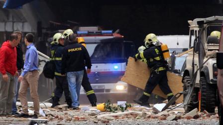 Policemen and firefighters inspect the scene of an explosion in downtown Prague, Czech Republic, Monday, April 29, 2013. Police said a powerful explosion has damaged a building in the center of the Czech capital and they believe some people are buried in the rubble.