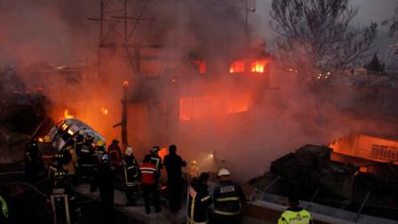 Firefighters work as a house burns after a gas tanker truck exploded on the highway in front of the house in the Mexico City suburb of Ecatepec, early Tuesday, May 7, 2013. (AP Photo/Gabriela Sanchez)