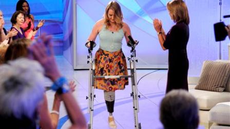 This image released by Disney-ABC Domestic Television shows host Katie Couric, right, applauding as Aimee Copeland, 24, of Snellville, Ga., who survived a rare fleshing-eating disease, as she arrives for an exclusive interview on the new daytime talk show Katie, Tuesday, Sept. 11, 2012, in New York. Copeland walked to the stage using a new walker. Copeland was joined in New York by her parents and sister. After Couric interviewed the family, she announced that an Atlanta-area Chevrolet dealer was in the studio to give Copeland a new minivan that will be retrofitted so she can drive it. Copeland got the infection in May after falling from a zip line and gashing her leg. Doctors had to amputate both hands, her left leg and right foot. She returned home to suburban Atlanta last week after three months in the hospital and a rehabilitation clinic. (AP Photo/Disney-ABC Domestic Television, Ida Mae Astute)