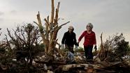 Lea Bessinger and her son Josh Bessinger look through the rubble of her tornado-ravaged home Tuesday, May 21, 2013, in Moore, Okla. A huge tornado roared through the Oklahoma City suburb Monday, flattening an entire neighborhoods and destroying an elementary school with a direct blow as children and teachers huddled against winds. 
