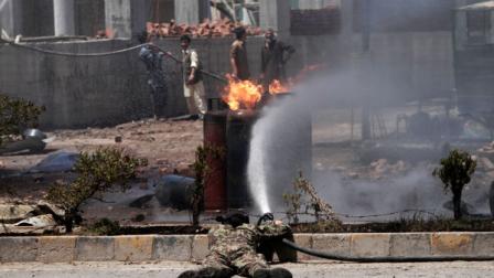 An Afghan firefighter sprays water at the scene of a propane gas explosion accident in Jalalabad, east of Kabul, Afghanistan, Friday, June 7, 2013. About thirty shops at the market were burnt down in the fire. Three people were injured, an official said. (AP Photo/Rahmat Gul)