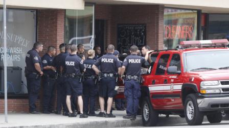 Los Angeles police officers gather in the citys westside Palms district where they investigated a home that was believed to be connected in some way with shootings in nearby Santa Monica,. Calif., Friday, June 7, 2013. A gunman with an assault-style rifle killed at least six people in Santa Monica on Friday before police shot him to death in a gunfight in a college library, authorities said. Police Chief Jacqueline Seabrooks told reporters the rampage began at a house in the coastal city before the gunman, dressed all in black, made his way to Santa Monica College. (AP Photo/Reed Saxon)
