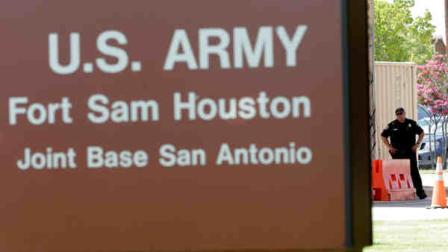 A guard stands at a gate to Fort Sam Houston, Monday, June 10, 2013, in San Antonio. San Antonio police have arrested a gunman for shooting at the main gate of the U.S. Army post. (AP Photo/Eric Gay)