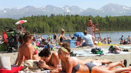 This photo taken Monday, June 17, 2013, shows people sunning at Goose Lake in Anchorage, Alaska. Parts of Alaska are setting high temperature records as a heat wave continues across Alaska. Temperatures are nothing like what Phoenix or Las Vegas gets, but temperatures in the 80s and 90s are hot for Alaska, where few buildings have air conditioning. (AP Photo/Mark Thiessen)