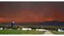 The smoke in the sky over a ranch near South Fork, Colo., glows red from a wildfire that is threatening the town on Friday, June 21, 2013. South Fork was evacuated Friday as the fire approaches from the west. (AP Photo/Ed Andrieski)  