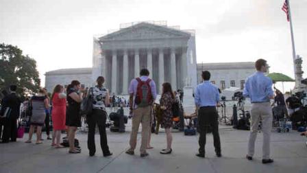 People wait outside the Supreme Court in Washington as key decisions are expected to be announced Monday, June 24, 2013. At the end of the courts term, several major cases are still outstanding that could have widespread political impact on same-sex marriage, voting rights, and affirmative action. (AP Photo/J. Scott Applewhite)