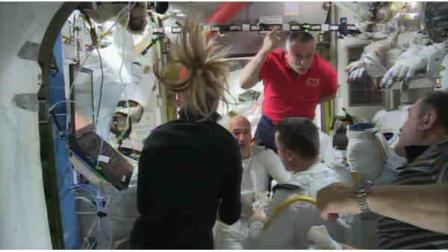 In this image from video made available by NASA, astronauts discuss the aborted spacewalk aboard the International Space Station on Tuesday, July 16, 2013. A dangerous water leak in the helmet of Luca Parmitano, bottom center facing camera in white suit, drenched his eyes, nose and mouth, preventing him from hearing or speaking as what should have been a routine spacewalk came to an abrupt end. (AP Photo/NASA)