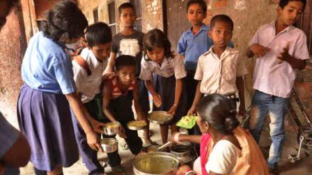 An Indian cook distributes free school lunches to children at a government run school in Patna, India, Wednesday, July 17, 2013. On Tuesday, at least 21 children died and more than two dozen others were sick after eating a free school lunch that was tainted with insecticide, in Gandamal village in Masrakh block, 80 kilometers (50 miles) north of Patna. (AP Photo/ Aftab Alam Siddiqui)
