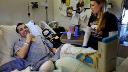 In this Thursday, May 9, 2013 photo, Marc Fucarile, left, jokes while speaking with members of the media as his fiancee, Jennifer Regan, right, looks on in his room at Massachusetts General Hospital in Boston. Fucarile was only feet away from a bomb blast Monday, April 15 near the finish line of the Boston Marathon that resulted in the loss of one leg, severe damage to the other, as well as burns, and a piece of shrapnel lodged in his heart. (AP Photo/Steven Senne)