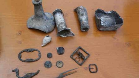 Items unearthed in Lower Manhattan are on display during a news conference, Wednesday, Aug. 7, 2013 in New York. Wine bottles corked centuries ago. A copper half-penny. A pair of childrens shoes.These are some of the remnants of early New York life workers discovered just steps from Wall Street while digging under Manhattan to install new utilities for the growing residential and business South Street Seaport area. (AP Photo/Mary Altaffer)