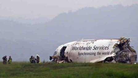 A UPS cargo plane lies on a hill at Birmingham-Shuttlesworth International Airport after crashing on approach, Wednesday, Aug. 14, 2013, in Birmingham, Ala. Toni Herrera-Bast, a spokeswoman for Birminghams airport authority, says there are no homes in the immediate area of the crash. (AP Photo/Butch Dill)