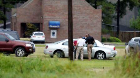 Louisiana law officers inspect a vehicle outside a Tensas State Bank branch during a hostage situation in St. Joseph, La., Tuesday, Aug. 13, 2013. A man whose family owns a store across the street from the bank took three bank employees hostage, and a state police negotiator has been talking to him for hours, police said. (AP Photo/Rogelio V. Solis)