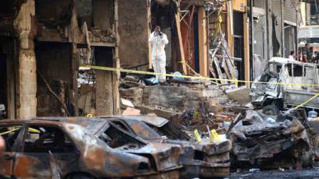 A Lebanese Army investigator, center, takes pictures at the site of a car bomb explosion, in an overwhelmingly Shiite area and stronghold of the Lebanese militant group Hezbollah, in a southern suburb of Beirut, Lebanon, Friday, Aug. 16, 2013. (AP Photo/Hussein Malla)