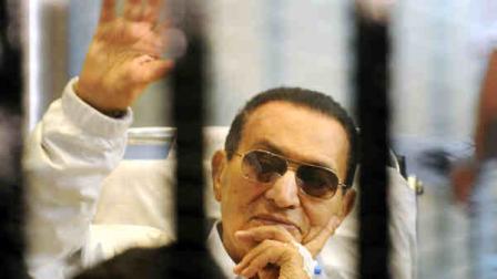 FILE - In this Saturday, April 13, 2013 file photo, former Egyptian President Hosni Mubarak waves to his supporters from behind bars as he attends a hearing in his retrial on appeal in Cairo, Egypt. Officials say an Egyptian court has ordered the release of ex-President Mubarak, but its not immediately clear whether the prosecutors will appeal the order. (AP Photo, File)