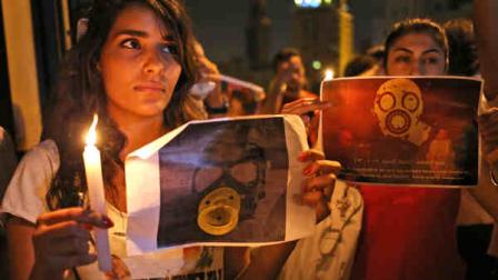 Syrian women who live in Beirut, hold candles and placards during a vigil against the alleged chemical weapons attack on the suburbs of Damascus, in front the United Nations headquarters in Beirut, Lebanon, Wednesday, Aug. 21, 2013. (AP Photo/Hussein Malla)