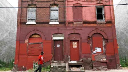 A man walks through a blighted neighborhood, Thursday, July 11, 2013, in Philadelphia. (AP Photo/Matt Rourke)
