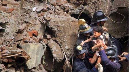 Indian Fire officials rescue a girl from debris of a collapsed building in Mumbai, India, Friday, Sept. 27, 2013. The multi-story residential building collapsed in Indias financial capital of Mumbai early Friday, killing at least three people and sending rescuers racing to reach dozens of people feared trapped in the rubble. (AP Photo)