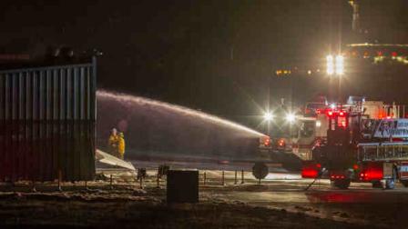 Firefighters work to extinguish fire at the site of a plane crash in Santa Monica, Calif., on Sunday, September 29, 2013. Authorities say a twin-jet Cessna Citation went off the right side of the runway and crashed into a hangar after landing about 6:20 p.m. It was not immediately clear how many people were on the plane or whether anyone was inside the hangar, and there was no immediate word on any injuries or deaths. (AP Photo/Ringo H.W. Chiu)