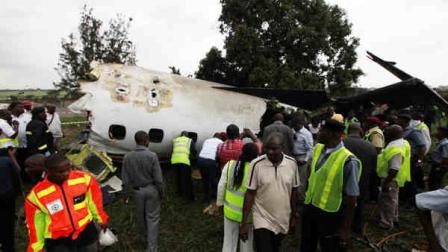 Rescue workers gather around the wreckage of a charter passenger jet which crashed soon after take off from Lagos airport, Nigeria, Thursday, Oct. 3, 2013. Officials said there were casualties but refused to confirm reports of several deaths. (AP Photo/Sunday Alamba)