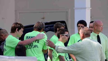 Pallbearers wearing anti-bullying t-shirts react after carrying the casket of Rebecca Sedwick,12, to a waiting hearse after exiting the Whidden-McLean Funeral Home Monday, Sept. 16, 2013, in Bartow, Fla. Polk County Sheriffs Office investigators say they believe Sedwick leaped to her death from a structure at an abandoned cement plant last week following months of bullying. (AP Photo/Brian Blanco)