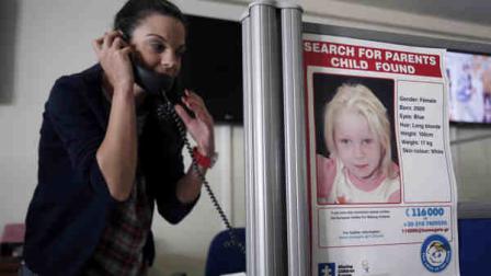 An employee of the Smile of the child speaks on the phone as a poster of the girl known as Maria is seen at the call center of the Greek charity in Athens, Monday, Oct. 21, 2013. (AP Photo/Thanassis Stavrakis)