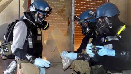 FILE -- In this Thursday, Aug. 29, 2013 file photo, a citizen journalism image provided by the Local Committee of Arbeen which has been authenticated based on its contents and other AP reporting, shows members of the UN investigation team take samples from the ground in the Damascus countryside of Zamalka, Syria. (AP Photo/Local Committee of Arbeen, File)