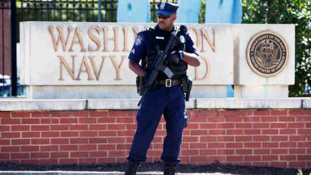 An armed officer who said he is with the Department of Defense, works near the gate at the Washington Navy Yard, closed to all but essential personnel, in Washington, on Tuesday, Sept. 17, 2013, the day after a gunman launched an attack inside the Washington Navy Yard on Monday, spraying gunfire on office workers in the cafeteria and in the hallways at the heavily secured military installation in the heart of the nations capital. (AP Photo/Jacquelyn Martin)