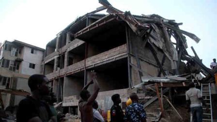 Police officers, rescue workers and onlookers gather near the site of a building under construction which collapsed in Lagos, Nigeria, Monday, Nov, 4. 2013. Emergency officials said casualty figures from the incident were unclear as they continued their search for survivors. (AP Photo/Sunday Alamba)