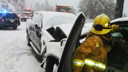 This image provided by the San Bernardino County Fire Department shows a traffic accident in the San Bernardino Mountains in California. The rain throughout the West led to flooding in San Bernardino County, where five homeless people were trapped by water and had to be rescued from the Santa Ana River, fire officials told the San Bernardino County Sun. (AP Photo/San Bernardino County Fire Department)