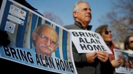 Supporters of Alan Gross, seen on poster at left, hold an event to mark his fourth year in prison in Cuba, Tuesday, Dec. 3, 2013, in Lafayette Park across from the White House in Washington. (AP Photo/Charles Dharapak)