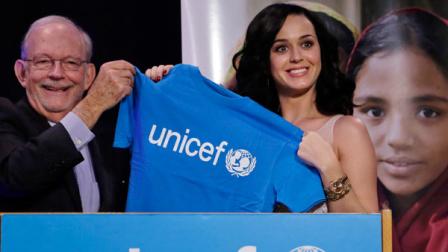 Singer Katy Perry, right, smiles as she and UNICEF Executive Director Anthony Lake hold a UNICEF shirt after she was appointed a UNICEF Goodwill Ambassador at UNICEF headquarters in New York, Tuesday, Dec. 3, 2013. (AP Photo/Richard Drew)