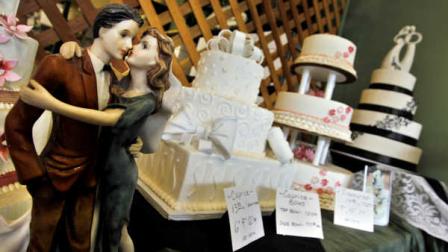 Figurines are depicted in an embrace as part of the wedding cake display at Masterpiece Cakeshop, in Denver, Thursday, June 6, 2013. A gay couple is pursuing a discrimination complaint against the Colorado bakery, saying the business refused them a wedding cake for a family reception because they are a gay couple, and alleging that the owners have a history of turning away same-sex couples. (AP Photo/Brennan Linsley)
