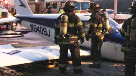 In this photo downloaded from the New York City Fire Departments Twitter account, firefighters stand near a light airplane that made an emergency landing on the Major Deegan Expressway in the Bronx borough of New York, Saturday, Jan. 4, 2014. Fire officials say all were taken to a hospital, but there have been no immediate reports of serious injuries. (AP Photo/New York City Fire Department)