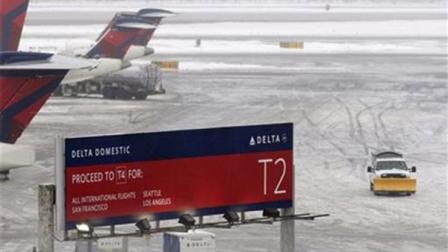 A snowplow makes its way on a slushy patch between two terminals after a Delta flight from Toronto to New York skidded off the runway into snow at Kennedy International Airport, temporarily halting all air travel into and out of the airport, Sunday, Jan. 5, 2014, in New York. (AP Photo/Kathy Willens)