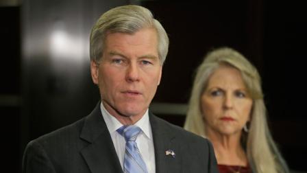 Former Virginia Governor Bob McDonnell makes a statement as his wife, Maureen, right, looks on during a news conference in Richmond, Va., Tuesday, Jan. 21, 2014. McDonnell and his wife were indicted Tuesday on corruption charges after a monthslong federal investigation into gifts the Republican received from a political donor. (AP Photo/Steve Helber)