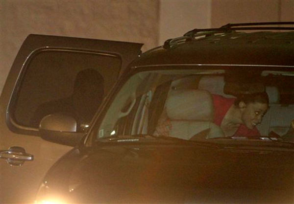 Casey Anthony, center, walks to a SUV with her...