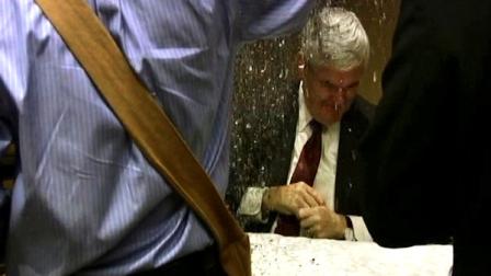 In this image taken from video, a protester dumps glitter on a table where GOP presidential hopeful Newt Gingrich and his wife, Callista, were signing books at a hotel in Minneapolis, Tuesday May 17, 2011. The man approached the Gingriches during the signing at a downtown Minneapolis hotel, dumped a cracker box full of confetti on the pair and said, Stop the hate! (AP Photo/Jeff Baenen)