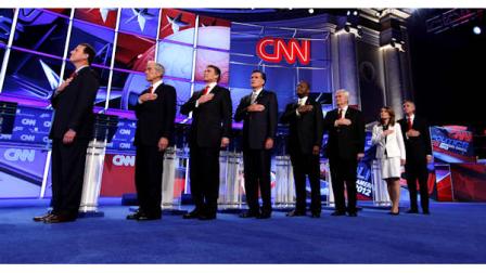 Republican presidential candidates from left, former Pennsylvania Sen. Rick Santorum, Rep. Ron Paul, R-Texas, Texas Gov. Rick Perry, former Massachusetts Gov. Mitt Romney, businessman Herman Cain, former House Speaker Newt Gingrich, Rep. Michele Bachmann, R-Minn., and former Utah Gov. Jon Huntsman stand for the National Anthem before a Republican presidential debate in Washington, Tuesday, Nov. 22, 2011. (AP Photo/Evan Vucci)