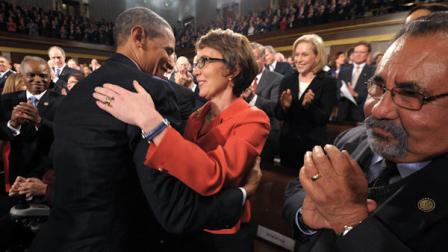 President Barack Obama embraces retiring Rep. Gabrielle Giffords, D-Ariz., as members of Congress applaud before his State of the Union address in front of a joint session of Congress Tuesday, Jan. 24, 2012, on Capitol Hill in Washington. (AP Photo/Saul Loeb)