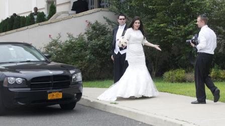 An unidentified bride and groom react at a Jewish wedding as the motorcade of Republican presidential candidate and former Massachusetts Gov. Mitt Romney drives past for a campaign fundraising event in Lakewood, N.J., Wednesday, Aug. 8, 2012. Romneys motorcade rolled into the fundraiser as a bride and groom were posing for pictures in the parking lot outside the hall in Lakewood. Several guests in yarmulkes who were standing around turned their cameras away from the couple, and a few chased the motorcade around the corner.(AP Photo/Charles Dharapak)