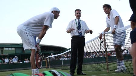 Referee Soeren Friemel, centre, calls off the epic mens singles match between John Isner of the US, left, and Nicolas Mahut of France,because of bad light, at the All England Lawn Tennis Championships at Wimbledon, Wednesday, June 23, 2010. (AP Photo/Alastair Grant)