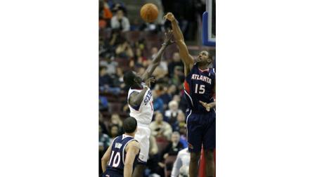Atlanta Hawks Al Horford (15) blocks a shot by Philadelphia 76ers Jrue Holiday in the first half of an NBA basketball game Friday, Oct. 29, 2010, in Philadelphia. (AP Photo/H. Rumph Jr.)