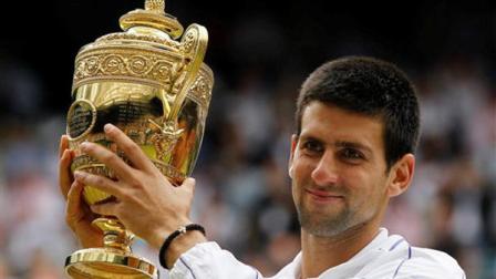 Serbias Novak Djokovic lifts the trophy after defeating Spains Rafael Nadal in the mens singles final at the All England Lawn Tennis Championships at Wimbledon, Sunday, July 3, 2011.