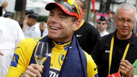 Tour de France winner Cadel Evans of Australia, wearing the overall leaders yellow jersey, is given a glass of wine on the Champs Elysees during the victory parade after winning the Tour de France cycling race in Paris, France, Sunday July 24, 2011. (AP Photo/Laurent Cipriani)