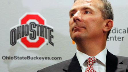 Urban Meyer listens as Ohio State athletic director Gene Smith introduces him as the universitys new football coach, during a news conference Monday, Nov. 28, 2011, in Columbus, Ohio. (AP Photo/Terry Gilliam)