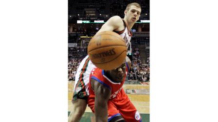 Philadelphia 76ers Jrue Holiday and Milwaukee Bucks Jon Leuer go after a loose ball during the first half of an NBA basketball game, Wednesday, April 25, 2012, in Milwaukee. (AP Photo/Morry Gash)