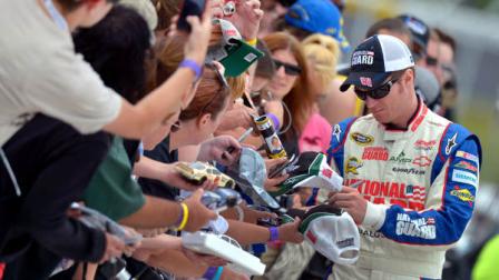 Dale Earnhardt Jr. signs autographs during qualifying for the NASCAR Sprint Cup Series auto race at Pocono Raceway, Saturday, June 9, 2012, in Long Pond, Pa. (AP Photo/Autostock, Brian Czobat) MANDATORY CREDIT