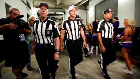 Officials walk toward the field before an NFL football game between the Baltimore Ravens and Cleveland Browns in Baltimore, Thursday, Sept. 27, 2012. (AP Photo/Patrick Semansky)